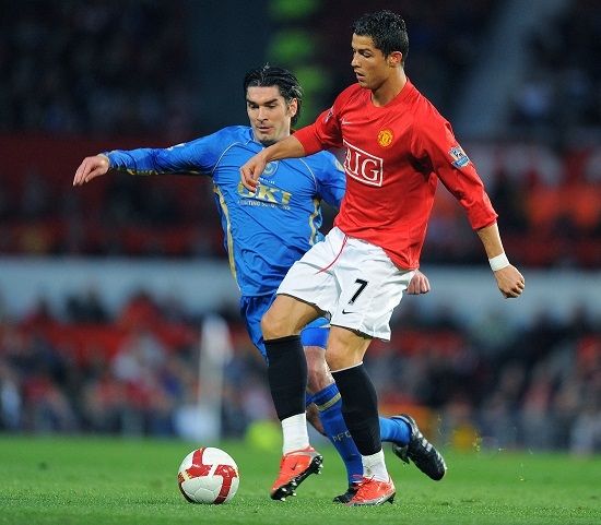 Pemain Portsmouth Richard Hughes mencoba menghentikan pemain Manchester United Cristiano Ronaldo dalam pertandingan Liga Premier Inggrid di musim 2008/09. [AFP]