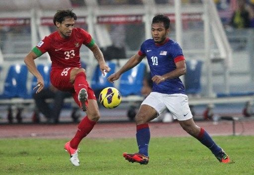 Pemain Malaysia Safee Sali berebut bola dengan pemain Indonesia dalam pertandingan Grup B Piala AFF 2012 di Stadion Bukit Jalil (1/12/2012). [AFP]