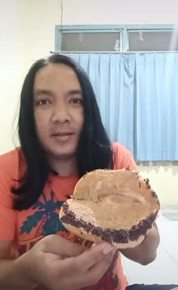 @abintangtimur saat menunjukkan roti yang berisi ke depan kamera dengan mimik wajah kecewa. (Tiktok/abintangtimur)