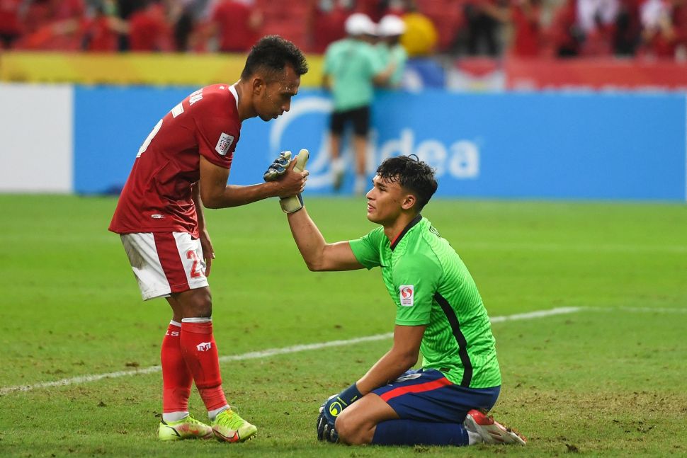 Pemain Indonesia Irfan Samaling Kumi (kiri) menghibur pemain Singapura Ikhsan Fandi setelah pertandingan leg kedua semifinal sepak bola Piala Suzuki AFF 2020 antara Singapura dan Indonesia di Stadion Nasional Singapura pada 25 Desember 2021. Roslan RAHMAN / AFP