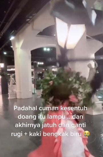 Perempuan menahan tiang lampu jatuh di sebuha mall. (TikTok/artemiisiia)