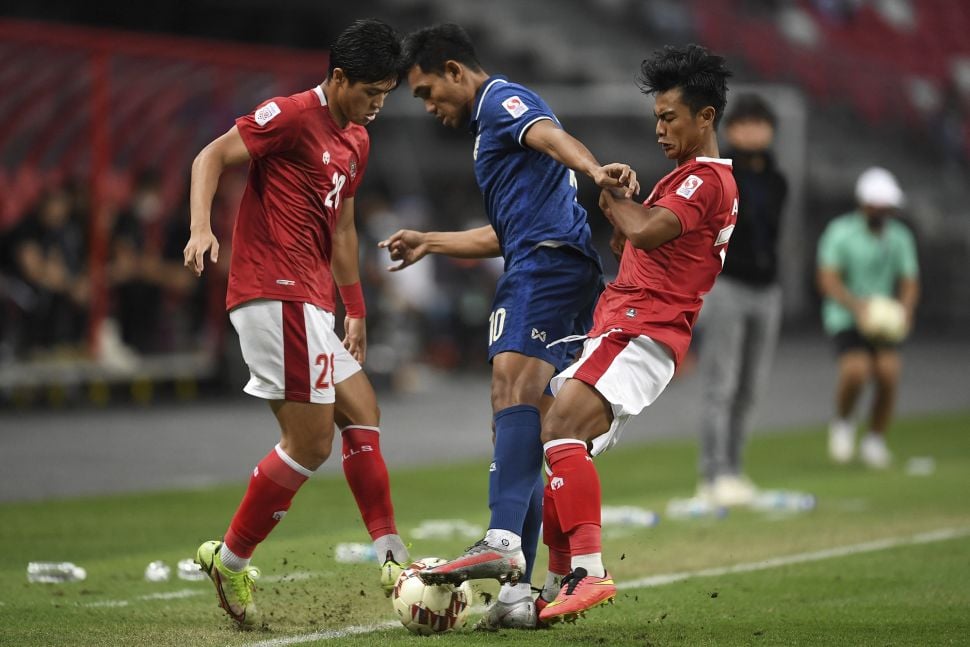 Pemain Indonesia Alfeandra Dewangga Santosa (kiri) berebut bola dengan pemain Thailand Teerasil Dangda pada pertandingan leg kedua final sepak bola Piala Suzuki AFF 2020 antara Thailand dan Indonesia di Stadion Nasional Singapura, pada (1/12/2022). [ROSLAN RAHMAN / AFP]