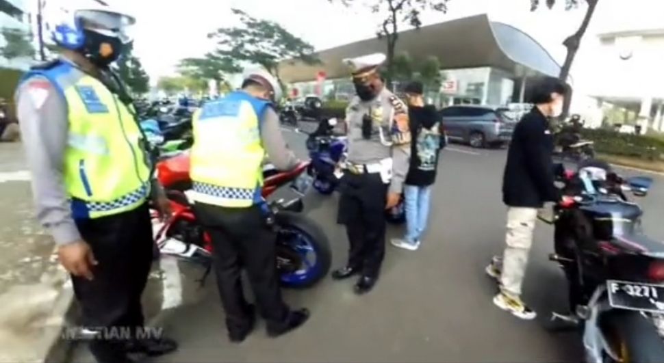 Tangkapan video viral polisi kuras tangki bensin motor yang ditilang Karena memakai knalpot bising di Pagedangan, Tangerang. [IST]