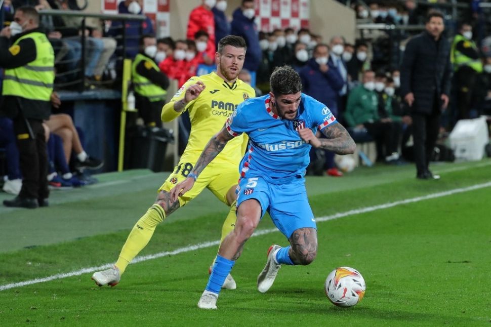 Gelandang Atletico Madrid asal Argentina Rodrigo De Paul (kanan) bersaing dengan bek Villarreal Alberto Moreno dalam pertandingan lanjutan Liga Spanyol antara Villarreal vs Atletico Madrid di stadion La Ceramica, Senin (10/1/2022) dini hari WIB.JOSE JORDAN / AFP.