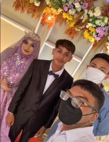 Potret dua orang foto bareng pengantin yang tak dikenal. (TikTok/tiohrz)