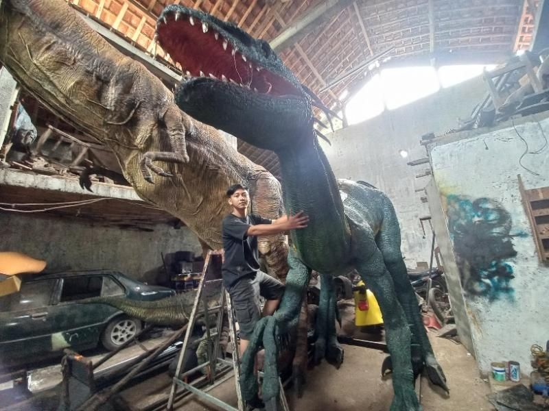 Iqbal memegang replika dinosaurus. [Rahmat Jiwandono / SuaraJogja.id]