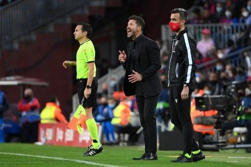 Pelatih Atletico Madrid Diego Simeone memberi instruksi dari pinggir lapangan saat timnya menghadapi Barcelona di Camp Nou, Minggu (6/2/2022). [AFP]