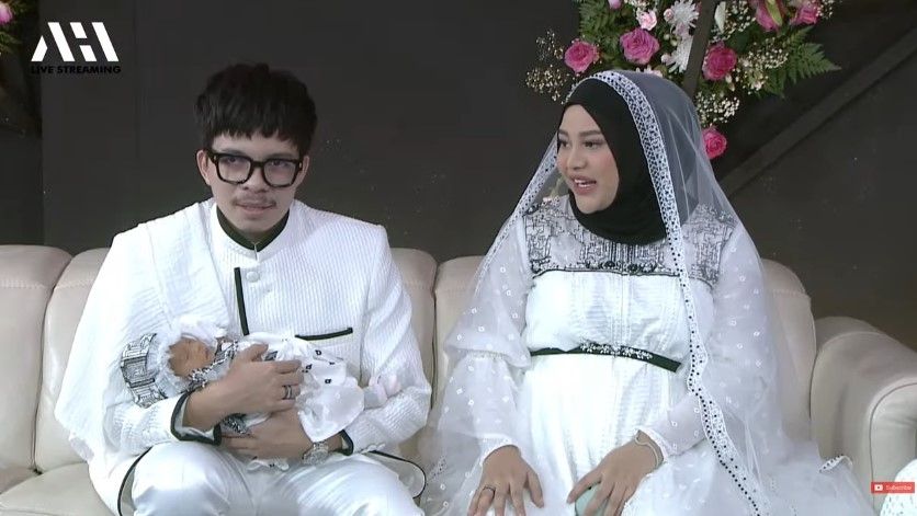 Atta Halilintar dan Aurel Hermansyah bersama putrinya Ameena Hana Nur Atta di acara akikahan sang putri yang berlangsung Jumat (4/3/2022). [YouTube AH]