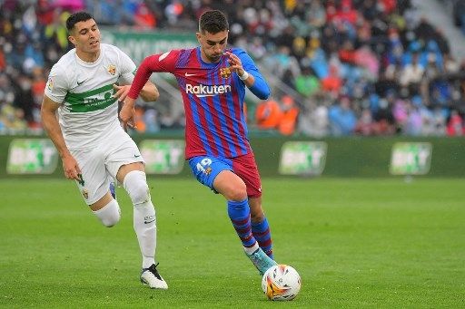 Pemain Barcelona Ferran Torres menjauh dari kejaran pemain Elche di laga tandang pekan ke-28 La Liga, Minggu (6/3/2022). [AFP]