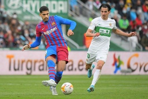 Pemain Barcelona Ronald Araujo melepaskan passing dalam pertandingan kontra Elche di pekan ke-28 La Liga, Minggu (6/3/2022). [AFP]