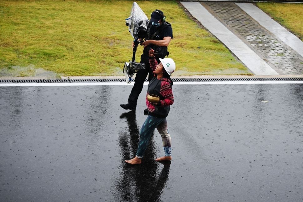 Pawang hujan Rara Isti Wulandari melakukan ritual saat hujan mengguyur Pertamina Mandalika International Street Circuit, Lombok Tengah, NTB, Minggu (20/3/2022). Start balapan MotoGP seri Pertamina Grand Prix of Indonesia sempat diundur dari jadwal semula karena cuaca buruk. ANTARA FOTO/Andika Wahyu