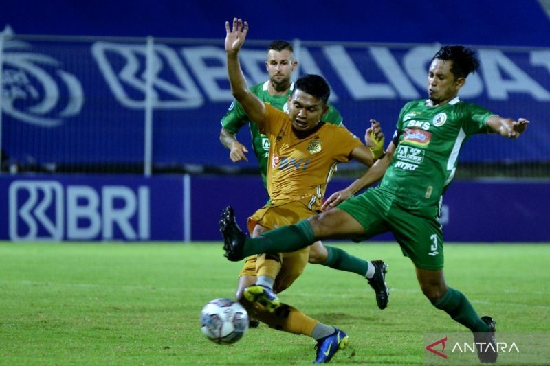 Pesepak bola Bhayangkara FC Dendy Sulistyawan (kiri) berebut bola dengan pesepak bola PSS Sleman Bagus Nirwanto (kanan) saat pertandingan Liga 1 di Stadion Kompyang Sujana, Denpasar, Bali, Senin (7/3/2022). ANTARA FOTO/Fikri Yusuf/hp.