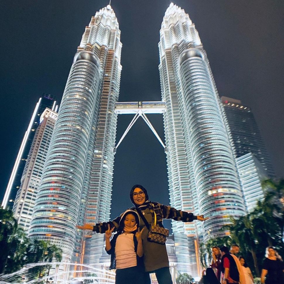 Umi Kalsum dan Bilqis berpose di depan menara kembar Petronas. [Instagram]