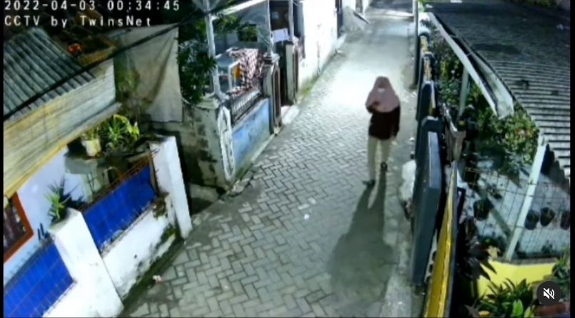 Seseorang berjilbab pink asyik berjalan sembari bermain ponsel. [Instagram]