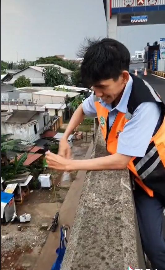 Publik dibuat terkagum-kagum oleh cara para petugas jalan tol saat ingin membeli takjil berbuka puasa Ramadhan 2022. Mirip seperti mancing, tapi bedanya ini dari atas jalan tol ke perkampungan bawah. [TikTok]