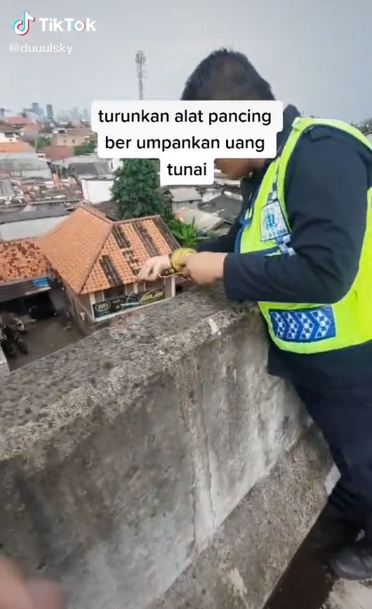 Publik dibuat terkagum-kagum oleh cara para petugas jalan tol saat ingin membeli takjil berbuka puasa Ramadhan 2022. Mirip seperti mancing, tapi bedanya ini dari atas jalan tol ke perkampungan bawah. [TikTok]