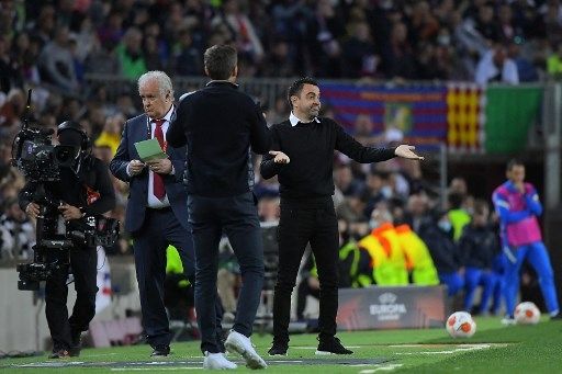 Gestur pelatih Barcelona Xavi Hernandez saat menyaksikan kekalahan timnya dari Eintracht Frankfurt di leg kedua babak perempat final Liga Europa yang digelar di Camp Nou, Jumat (15/4/2022). [AFP]