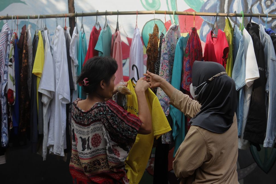 Warga memilih pakaian bekas layak pakai yang dijajakan secara gratis di Jalan Jati Padang VI RT 002 RW 004, Pasar Minggu, Jakarta, Minggu (17/4/2022). [Suara.com/Angga Budhiyanto]