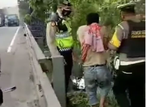 Seorang lelaki di Surabaya, Jawa Timur, terekam video amatir hendak bunuh diri dari atas papan reklame di Tol Satelit, Sukomanunggal. [Instagram]