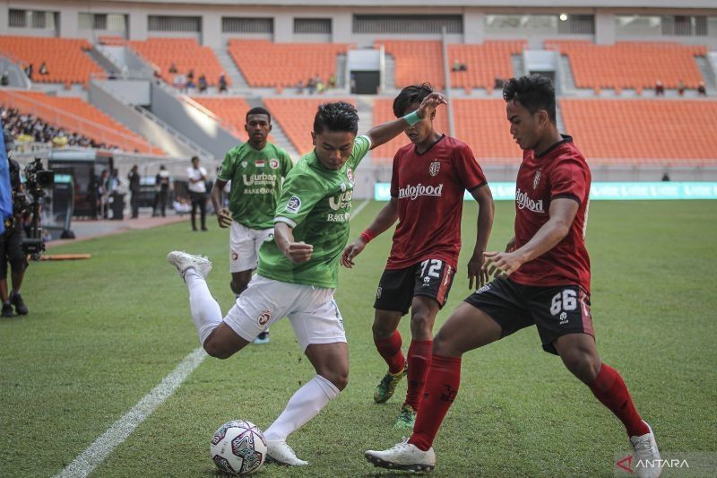 Pesepak bola Indonesia All Stars U-20 Cecep Mulyana (kiri) berebut bola dengan pesepak bola Bali United U-18 I Gede Agus Mahendra (kanan) pada pertandingan International Youth Championship (IYC) 2021 di Jakarta International Stadium, Jakarta, Jumat (15/4/2022). ANTARA FOTO/Dhemas Reviyanto/foc.