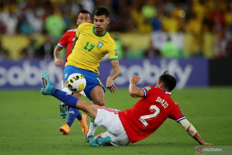 Pesepak bola Brazil Bruno Guimaraes (kiri) berebut bola dengan pesepak bola Chile Gabriel Suazo (kanan) dalam laga Kualifikasi Piala Dunia 2022 zona Amerika Selatan, di Stadion Maracana, Rio de Janeiro, Brazil, Kamis (24/3/2022). Brazil berhasil mengalahkan Chile 4-0. ANTARA FOTO/Reuters-Ricardo Moraes/hp.