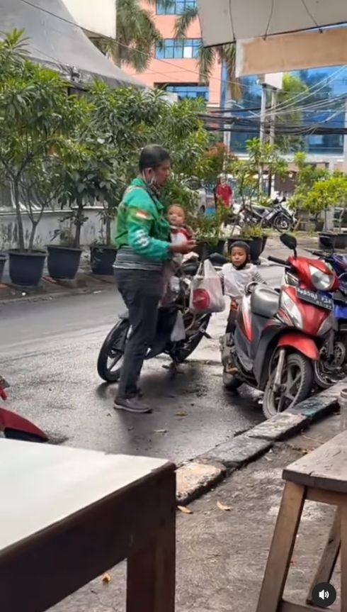 Seorang driver ojol mengantarkan pesanan sembari mengasuh kedua anaknya ini, membuat warganet terharu. [Instagram]