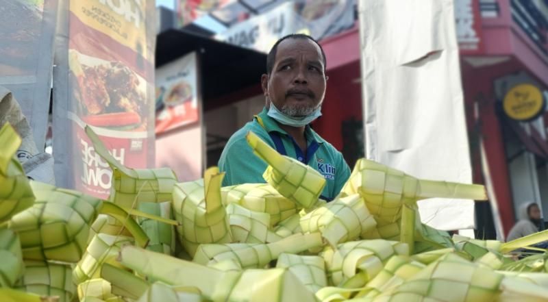 Penjual bungkus ketupat di Jalan Affandi, Mrican, Caturtunggal, Depok, Kabupaten Sleman, Minggu (1/5/2022). [Hiskia Andika Weadcaksana / SuaraJogja.id]