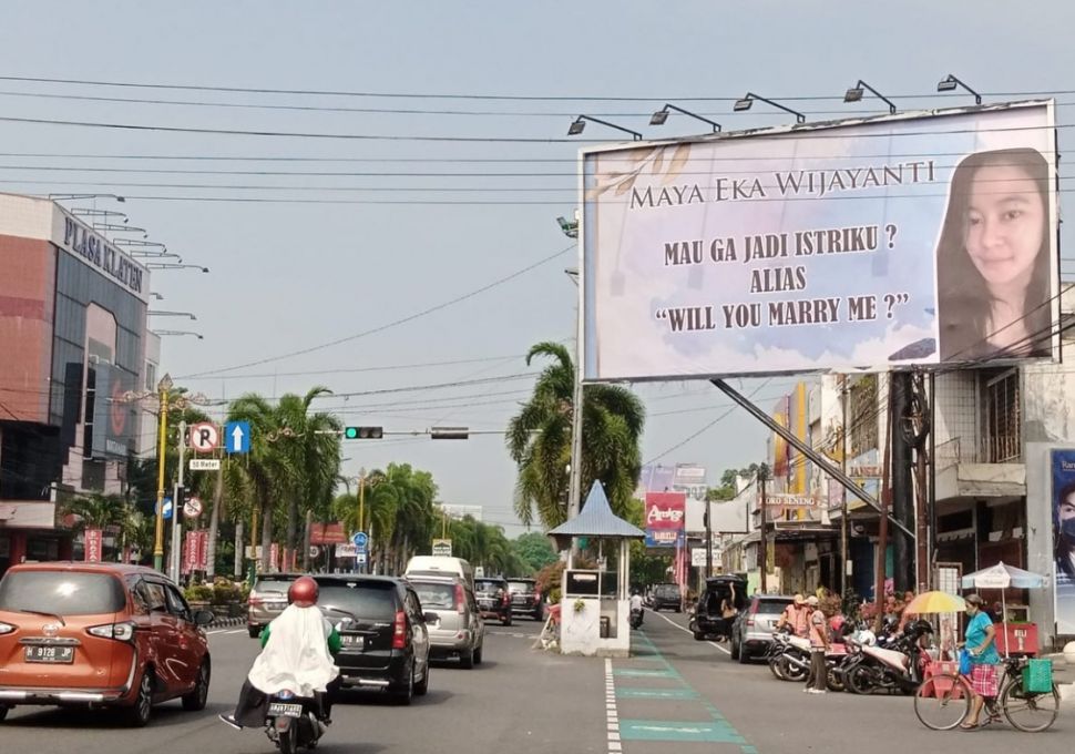 Viral foto-foto baliho raksasa Tommy Aditya yang mengajukan permohonan agar Maya Eka Wijayanti mau menjadi istrinya. [Facebook/Rie No]