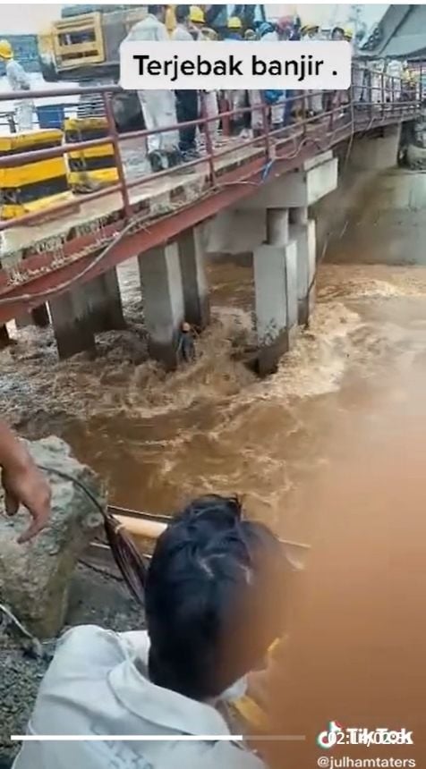 Video mencekam seorang pekerja terjebak air banjir di bawah jembatan viral di media-media sosial, Rabu (18/5/2022). [Instagram/@andreli_48]