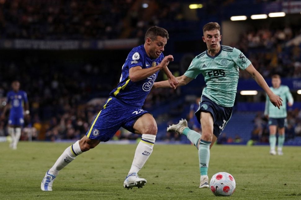 Bek Chelsea, Cesar Azpilicueta (tengah) coba melewati bek Leicester City, Luke Thomas (kanan) dalam laga tunda pekan ke-27 Liga Inggris 2021/2022 di Stamford Bridge, London, Jumat (20/5/2022) dini hari WIB. Adrian DENNIS / AFP.