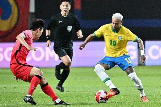 Pemain Brasil Neymar mencoba melewati pemain Korea Selatan dalam laga persahabatan di Stadion Piala Dunia Seoul di Seoul, Korea Selatan, 2 Juni 2022. [AFP]