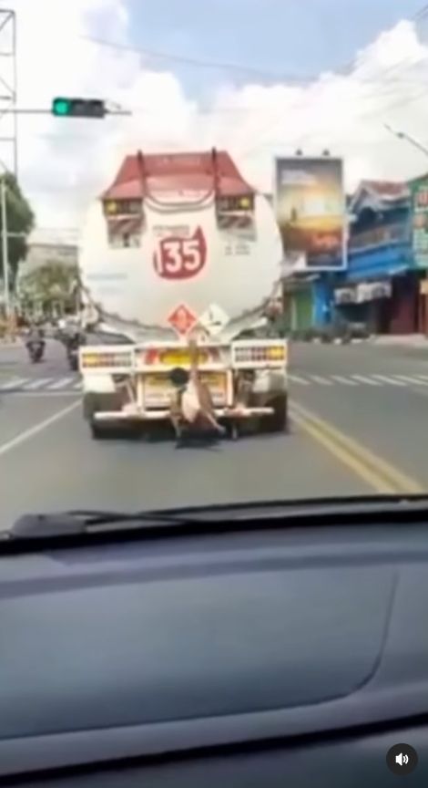 Orang dengan gangguan kejiwaan atau ODGJ terekam video bergelantungan di belakang truk tangki BBM yang sedang berjalan. [Instagram]