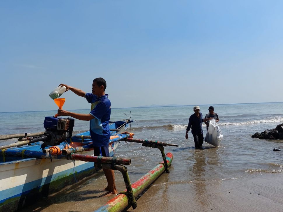 BENSIN PLAS- Salah satu nelayan menggunakan Bensin Plas yang diproduksi melalui IPST-ASRI dengan bahan baku sampah plastik, Kamis (30/6/2022). Pengumpulan sampah plastik yang dilakukan nelayan dan masyarakat untuk didaur ulang menjadi bahan bakar dan aspal itu diinisiasi oleh PT Chandra Asri Petro Chemical. [Suara.com/Hairul Alwan]