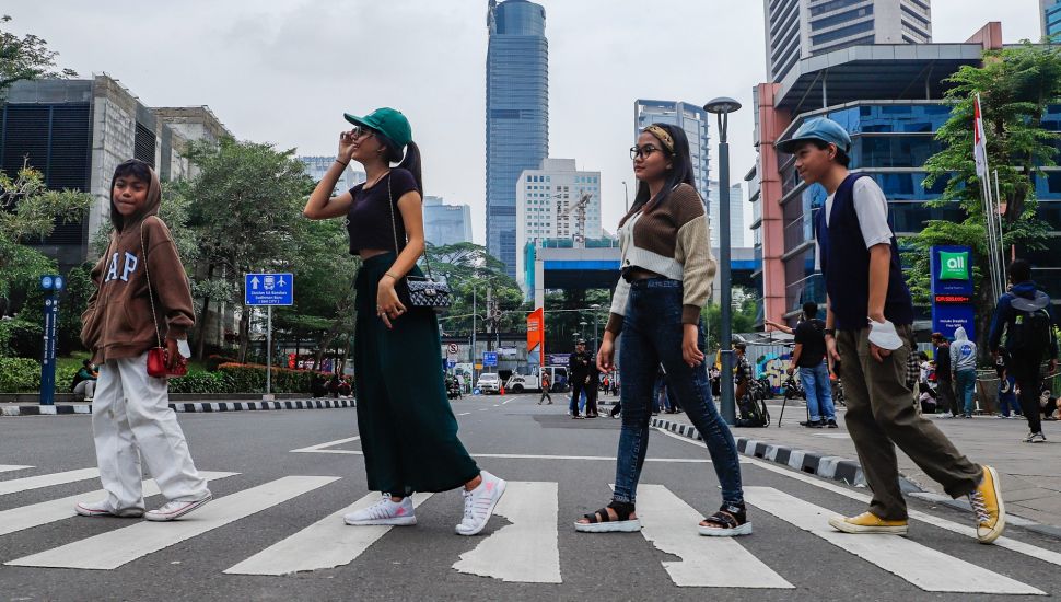 Sejumlah remaja berpose saat difoto di Kawasan Dukuh Atas, Jakarta Pusat, Rabu (6/7/2022). [Suara.com/Alfian Winanto]