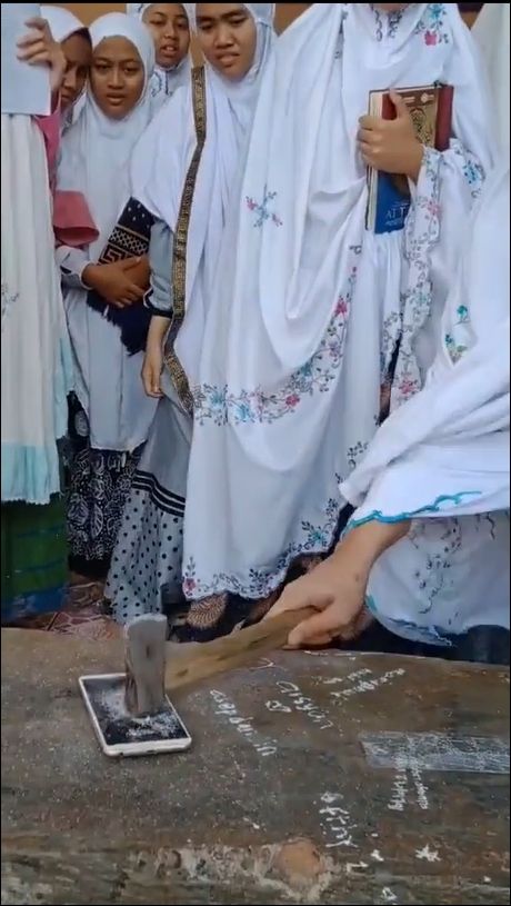 Video viral pengurus pondok pesantren menghancurkan telepon seluler atau ponsel milik santriwatinya, memicu perdebatan publik. [Instagram]