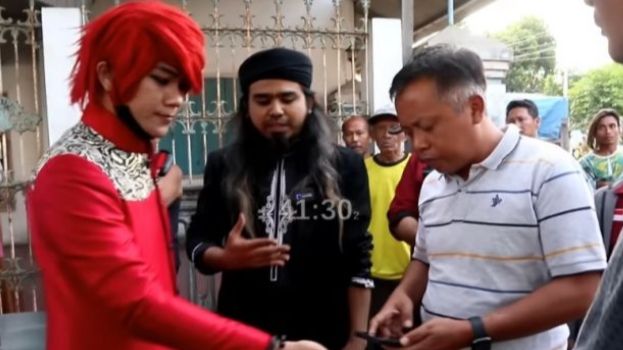Marcel Radhival alias Pesulap Merah saat mendatangi padepokan Gus Samsudin (tengah), namun sempat dihalangi dan dimintai KTP-nya oleh kepala desa (kanan). [YouTube/Marcel Radival]