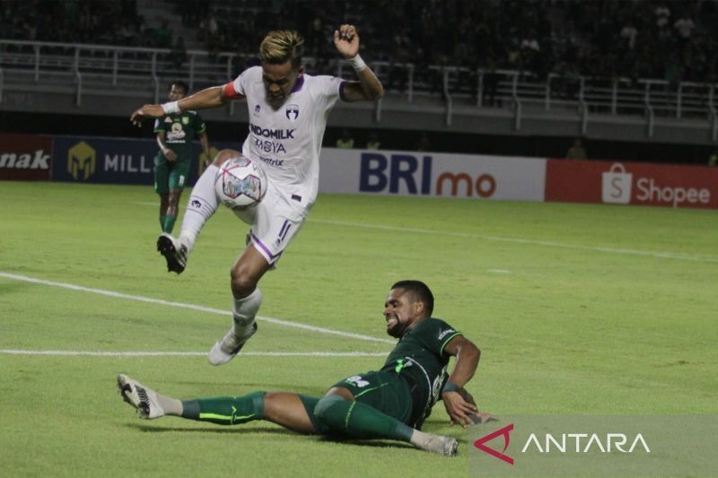 Kapten Persita Tangerang Muhammad Toha melompat untuk menghindari tekel Silvio Junior pada pertandingan Persebaya vs Persita di Stadion Gelora Bung Tomo Surabaya, Senin (1/8/2022) malam. (ANTARA/Moch Asim)