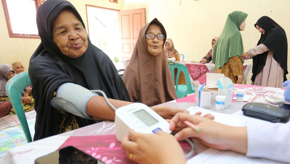 Petugas kesehatan memeriksa tekanan darah dari seorang warga lanjut usia (lansia) di Posyandu Ayeum Mata, Desa Alue Raya, Samatiga, Aceh Barat, Aceh, Rabu (31/8/2022). [ANTARA FOTO/Syifa Yulinnas/wsj]