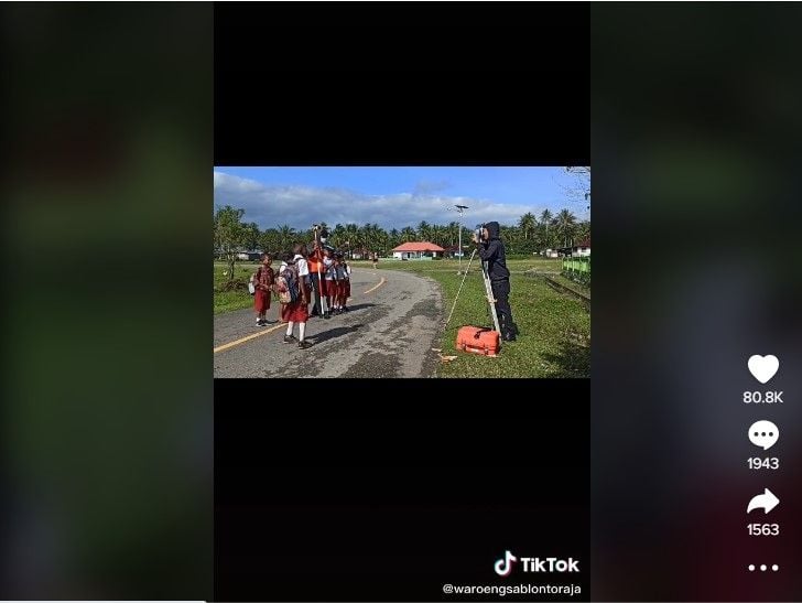 Para bocah SD berfoto di depan alat pengukur tanah, mengira itu adalah kamera. (TikTok / @waroengsablontoraja)