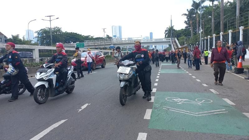 Massa buruh demo tolak kenaikan BBM dengan mendorong sepeda motor ke gedung DPR RI. (Suara.com/Bagaskara)