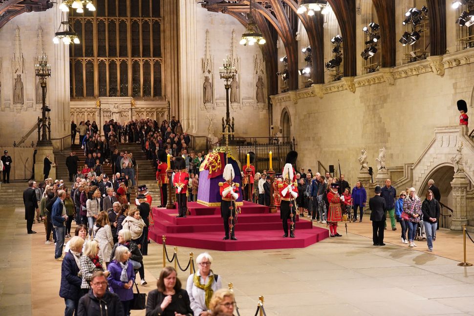 Orang-orang memberikan penghormatan di dekat peti mati mendiang Ratu Elizabeth II, yang terbaring di catafalque di Westminster Hall di Istana Westminster di London, Inggris, Jumat (16/9/2022). [AFP Photo]