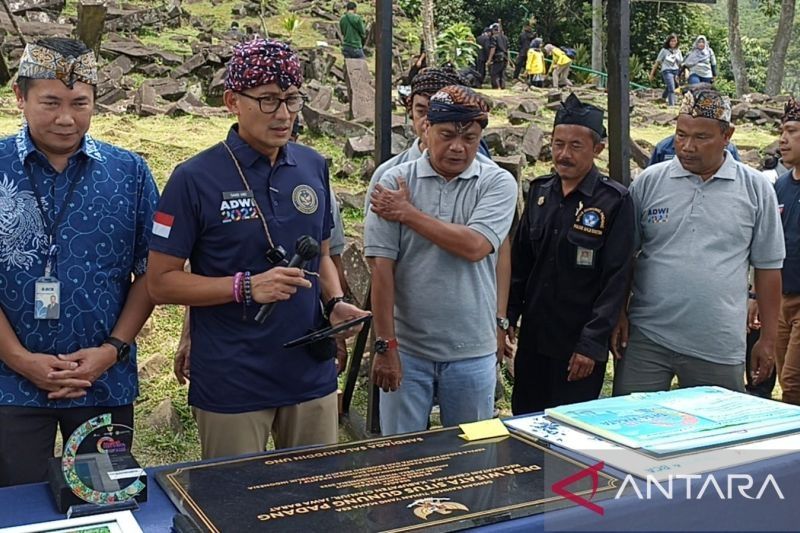 Menteri Pariwisata dan Ekonomi Kreatif (Menparekraf) Sandiaga Salahuddin Uno, memberikan Anugerah Desa Wisata Terbaik untuk Situs Meghalit Gunung Padang, didampingi Kadisbudpar Cianjur, Jawa Barat, Pratama Nugraha, Kamis (22/9/2022). [ANTARA/Ahmad Fikri]