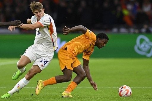 Pemain Belanda Tyrell Malacia menghentikan laju pemain Belgia dalam pertandingan UEFA Nations League di Amsterdam Arena, Senin (26/9/2022). [AFP]