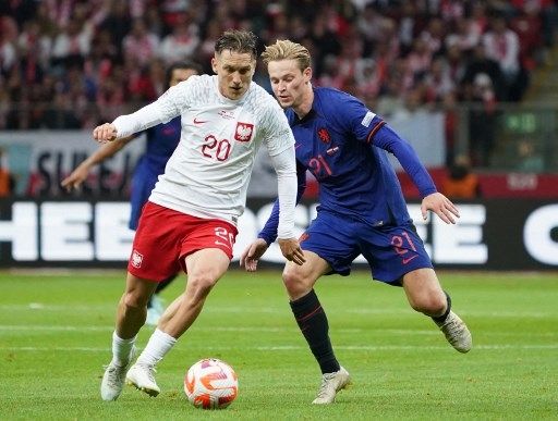 Pemain Timnas Belanda Frenkie de Jong (jersey biru) berebut bola dengan pemain Polandia dalam pertandingan UEFA Nations League di Warsawa, 22 September 2022. [AFP]