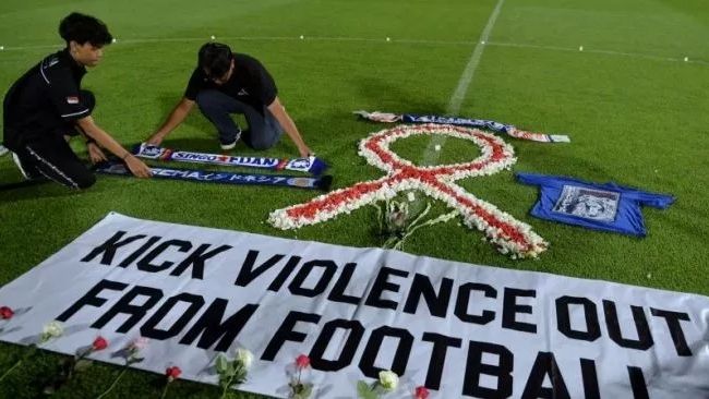 Suporter sepak bola meletakkan atribut Arema saat mengikuti doa bersama bagi korban Tragedi Kanjuruhan di Stadion Kapten I Wayan Dipta, Gianyar, Bali, Senin (3/10/2022). [ANTARA FOTO/Fikri Yusuf]