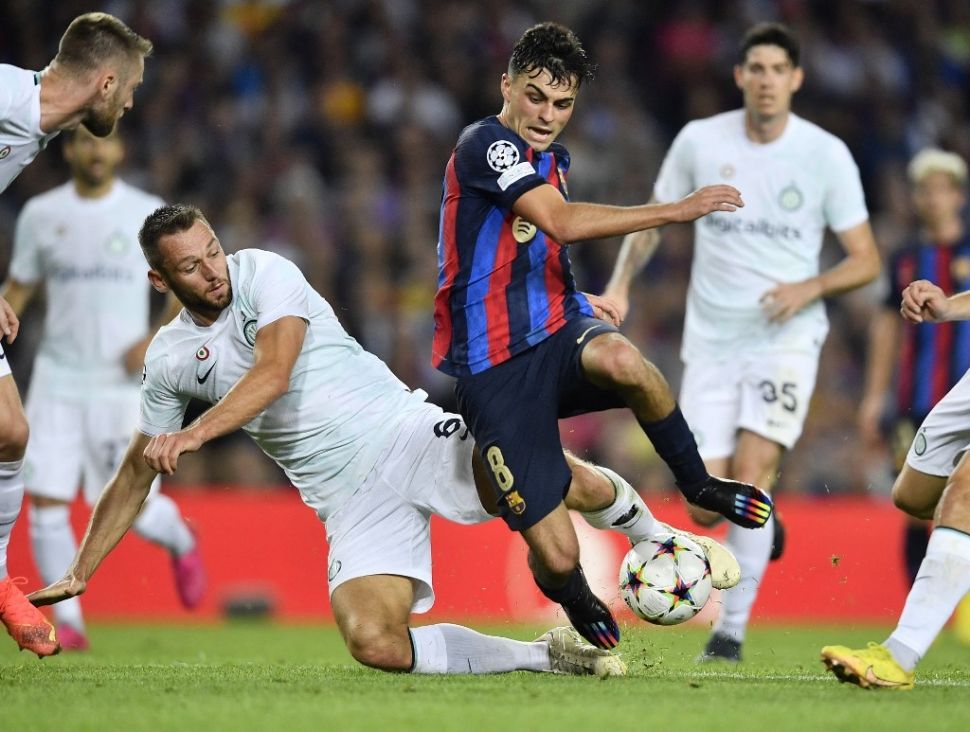 Bek Inter Milan, Stefan de Vrij (kiri) bersaing dengan gelandang Barcelona, Pedri selama matchday keempat Grup C Liga Champions antara FC Barcelona vs Inter Milan di stadion Camp Nou di Barcelona pada 12 Oktober 2022.Pau BARRENA / AFP.