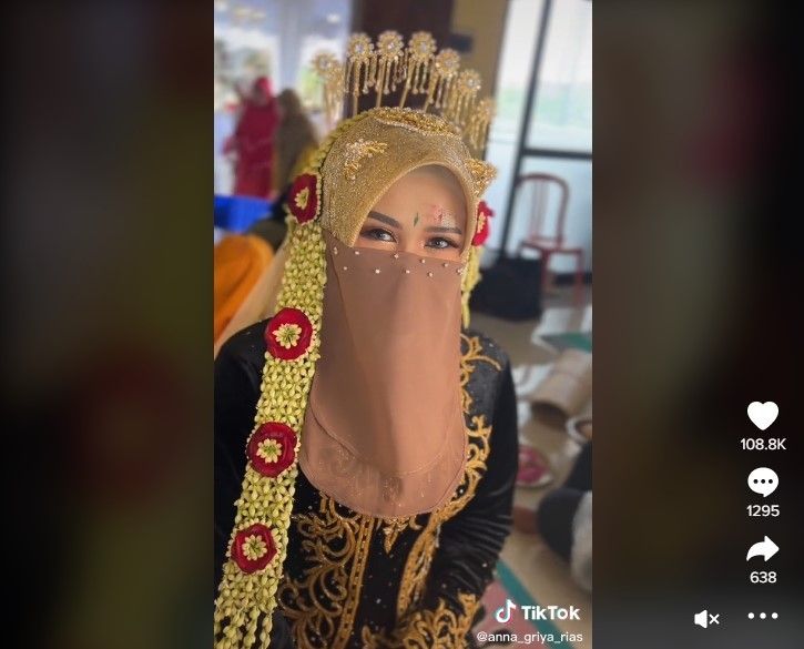 Seorang pengantin perempuan mengenakan cadar untuk menutupi luka di wajahnya. (TikTok / @anna_griya_rias)