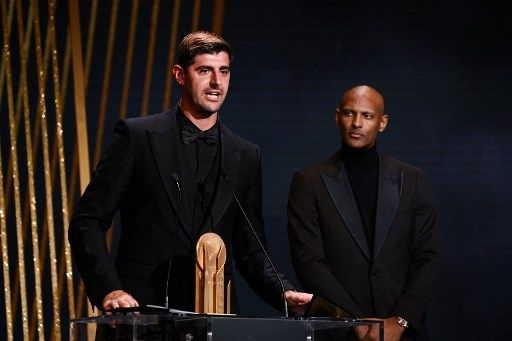 Penjaga gawang Real Madrid asal Belgia, Thibaut Courtois (kiri) menerima Trofi Yashin untuk penjaga gawang terbaik dari penyerang Dortmund, Sebastien Haller, pada upacara penghargaan Ballon d'Or France Football 2022 di Theater du Chatelet di Paris pada 17 Oktober 2022.FRANCK FIFE / AFP