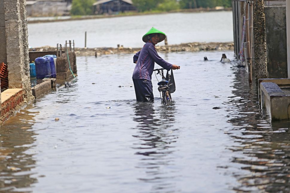 Warga menerobos genangan banjir rob atau air laut pasang merendam Desa Eretan Wetan, Kandanghaur, Indramayu, Jawa Barat, Rabu (9/11/2022). [ANTARA FOTO/Dedhez Anggara/YU]