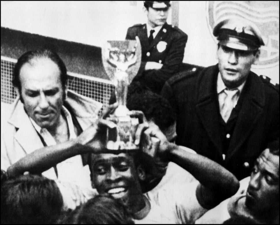 Penyerang Brasil Pele tersenyum saat ia memegang Piala Jules Rimet setelah Brasil mengalahkan Italia 4-1 di final Piala Dunia 1970 di Mexico City pada 21 Juni 1970. [STF / AFP]